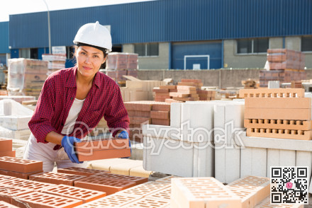 Female builder working in outdoor storage