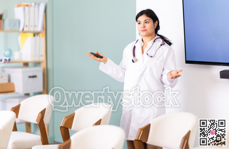 Woman doctor with remote control in lecture hall