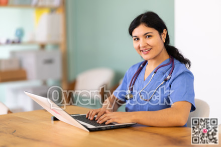 Female doctor works on laptop in room
