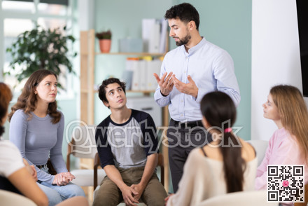 Male teacher talking to interested students sitting in a circle