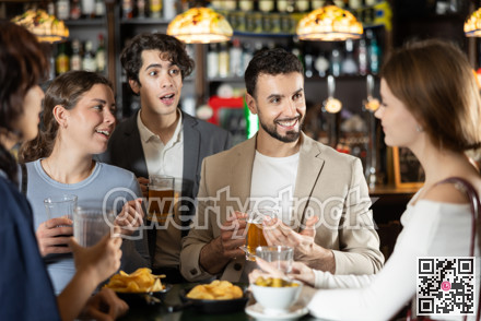 Group of friends at bar talking and drinking beer