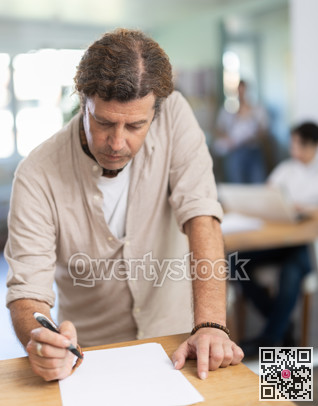 Portrait of manager reading and signing documents in modern office