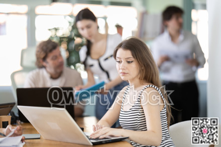 Young woman working on laptop in modern office
