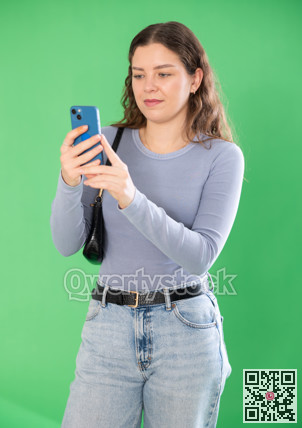 Happy girl scans QR code or takes photo with a smartphone. Green background. Chroma key compositing
