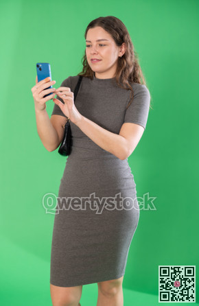 Happy girl scans QR code or takes photo with a smartphone. Green background. Chroma key compositing