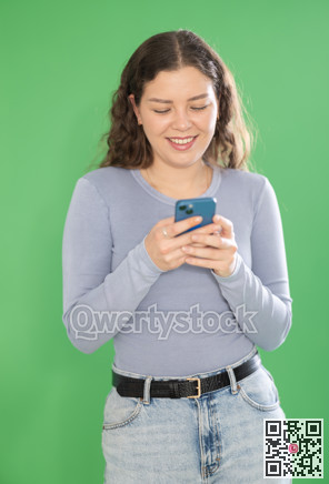 Pretty young girl scrolling through smartphone screen against green screen background. Chroma key compositing.