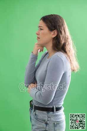 Young woman sad and upset in front of green screen
