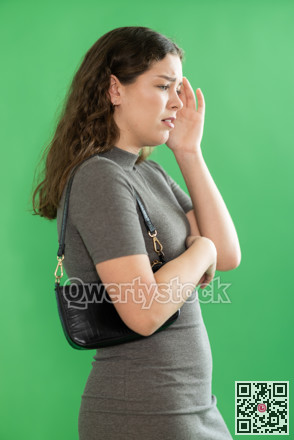Young woman sad and upset in front of green screen