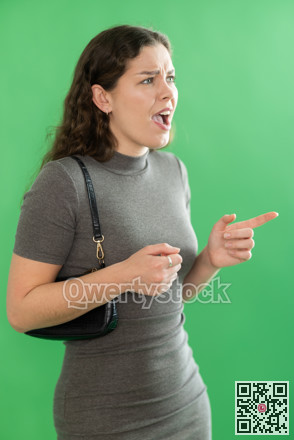 Young woman angry and yelling in front of green screen