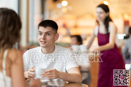 Guy in cafe sits opposite female companion, has nice conversation