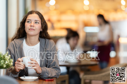 Girl whiles away time and waits for meeting in chain cafe
