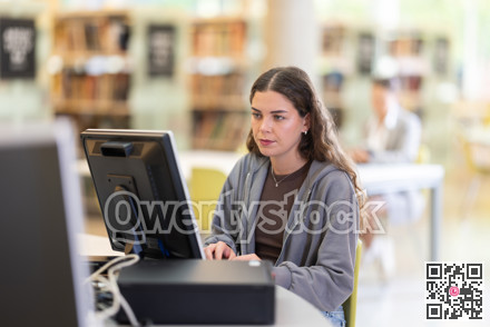 Female student works at computer in library