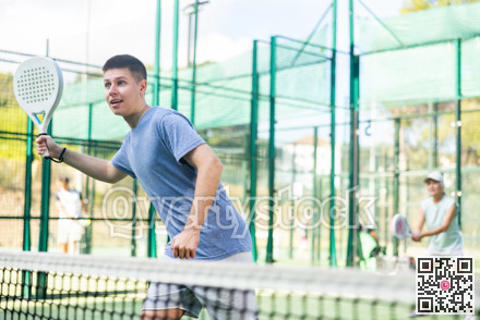Young man playing padel tennis on court