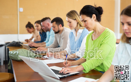 Group students listening and writing during business course