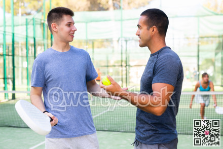 Men chatting on outdoor padel tennis court