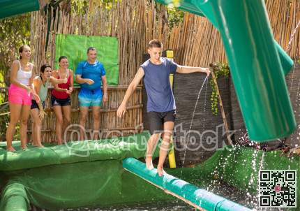 Boy walking through water obstacle course in amusement park