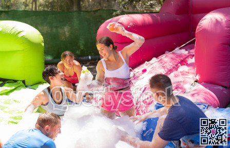Positive men and women playing interesting game in bubble pool