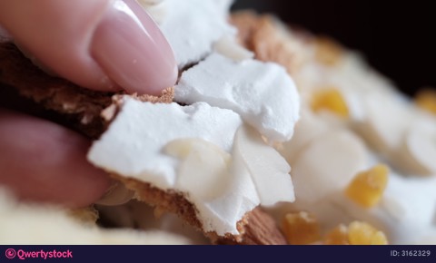 Macro breaking white icing on Easter kulich almond flakes and candied fruit close-up texture crust sweet bread detail video 3162329