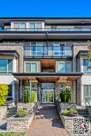 Entrance of residential apartment building with paved pathway in front
