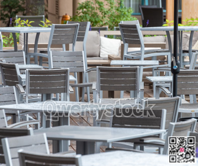 Vacant tables of a street cafe under the rain