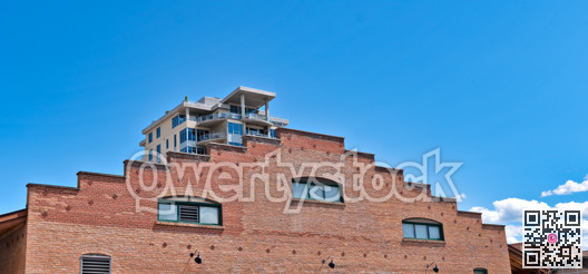 Brick wall of historic building with modern building on the back