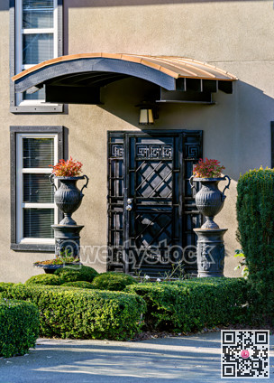 Metal grid door of a residential house with lightweight cover over the entrance