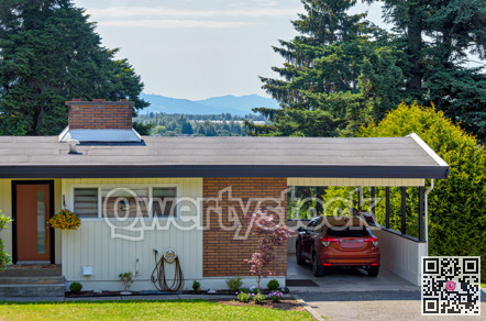 Average family house with mountain view and red car parked under the carport