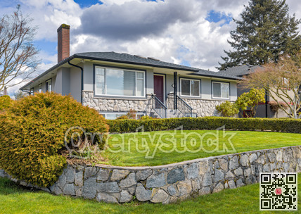 Average residential house with green lawn on land terrace in front