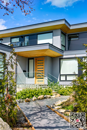 Neat entrance of modern residential house on blue sky background