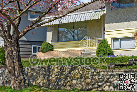 Entrance of the family house under the canopy with front lawn on the land terrace