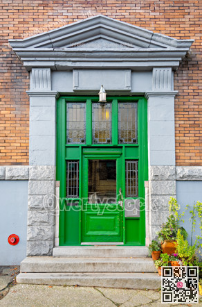Entrance of old residential building in Vancouver decorated with flower pots