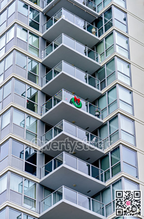 Corner of a residential high-rise building with balconies decorated for Christmas