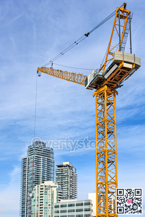 High-attitude crane and high-rise residential buildings on blue sky background