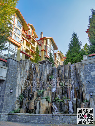 Residential block with decorative waterfall on sunset time in Whistler