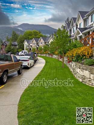 Row of residencial townhouses with cars parked on the street after the rain