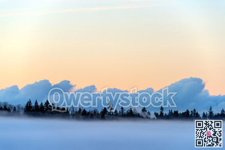 Foggy winter evening on puffy clouds and clear sky background
