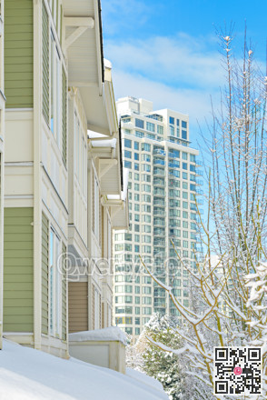 Residential townhouses and high-rise building on bright winter day