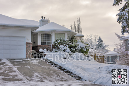 Big residential house with rotonda in snow on overcast winter day