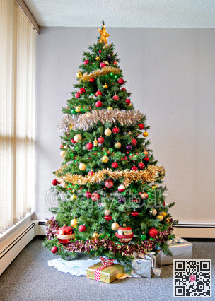 Tall Christmas tree decorated with balls, lights, and glittering firs