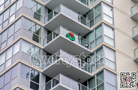 Corner of a residential high-rise building with balconies decorated for Christmas