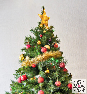 Golden star and colourful balls with color electtric lights decorating top of artificial Christmas tree