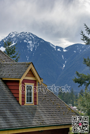 Top of residential house with mountain view and overcast sky background