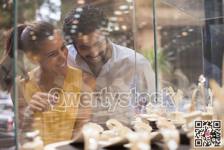 Middle Eastern couple happily choosing a wedding ring together at a jewelry store with family photo 3204408