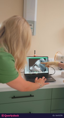Dentist with Assistant Looking Jaw X-ray on Laptop to Prescribe Dental Treatment video 1641076